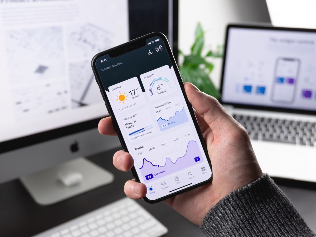 Info Grove App User looking at computer and phone app